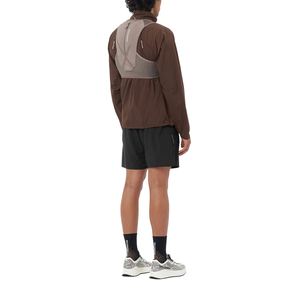 Angled view of a model wearing the Salomon Unisex GRVL Skin 4 Running Vest in the Iron/Silver Cloud colourway.