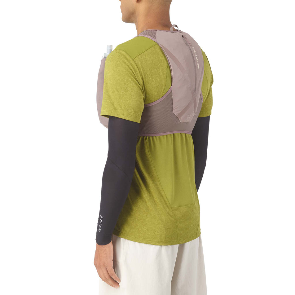 Angled view of a model wearing the Salomon Unisex GRVL Skin 4 Running Vest in the Iron/Silver Cloud colourway.