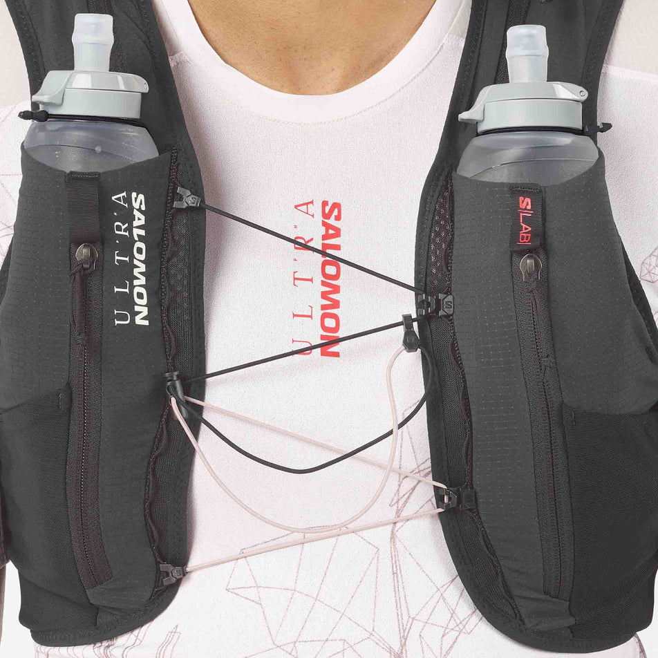 Front view of a model wearing the Salomon Unisex S/LAB Ultra 12 Running Vest in the Black colourway.
