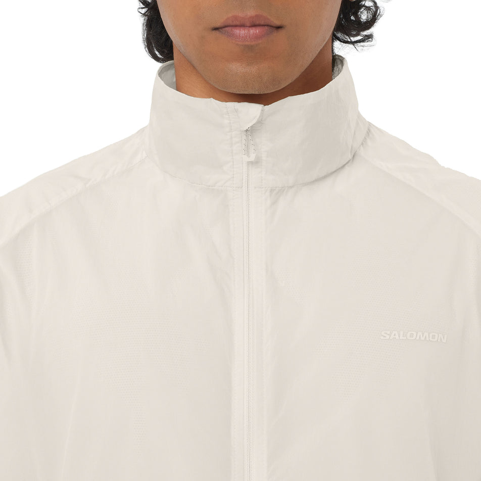 Front view of a model wearing the Salomon Men's SHKout Fly Jacket in the Whisper White colourway.