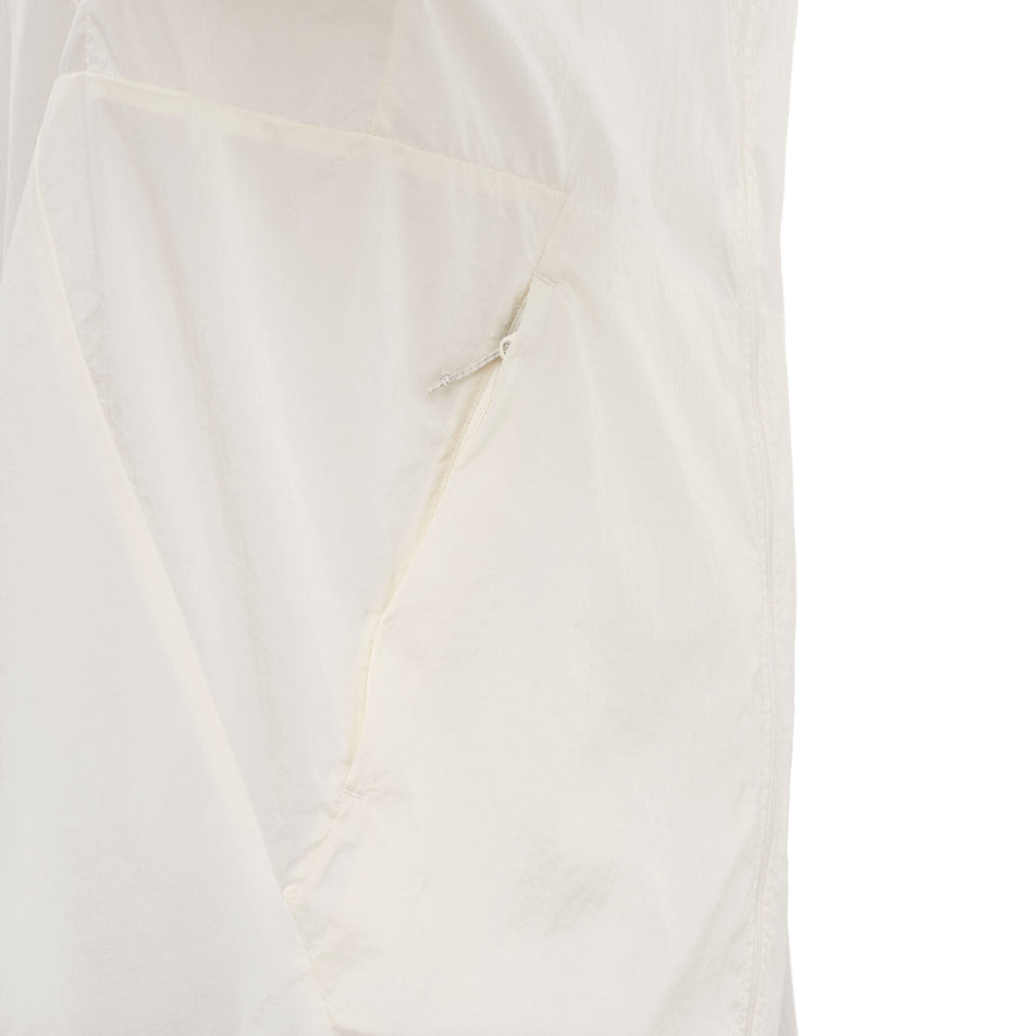 Close-up view of the zip pocket on the Salomon Men's SHKout Fly Jacket in the Whisper White colourway.