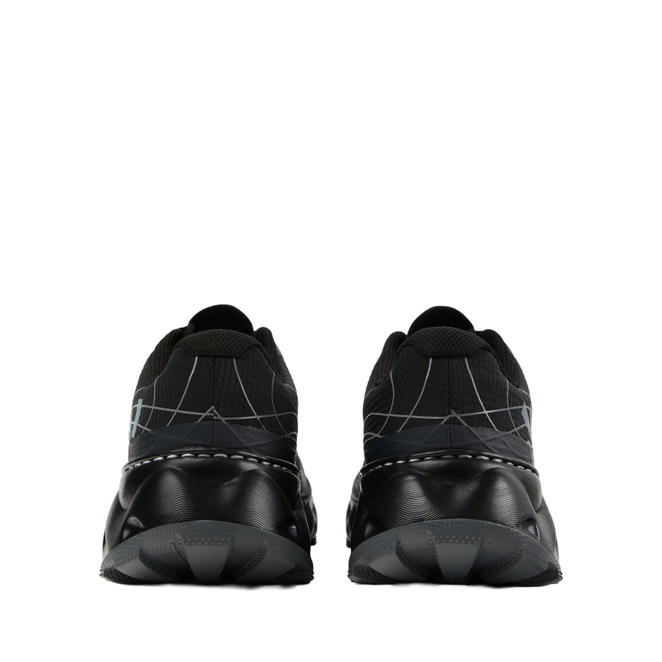 The back of a pair of NNormal Unisex Tomir 2.0 Running Shoes in the Black colourway. (8742924746914)