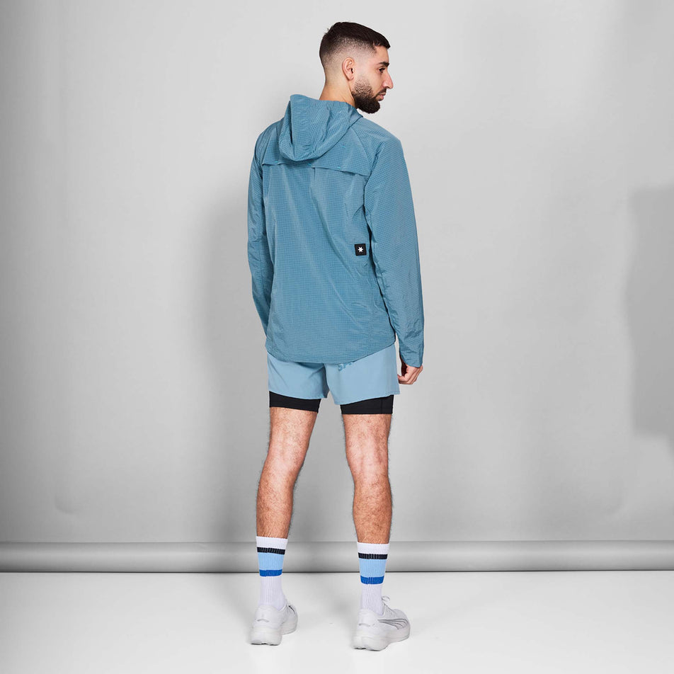 Back view of a model wearing the SAYSKY Men's Clean Pace Shield Jacket in the Blue colourway. Model is also wearing shoes, socks and shorts. (8601240633506)
