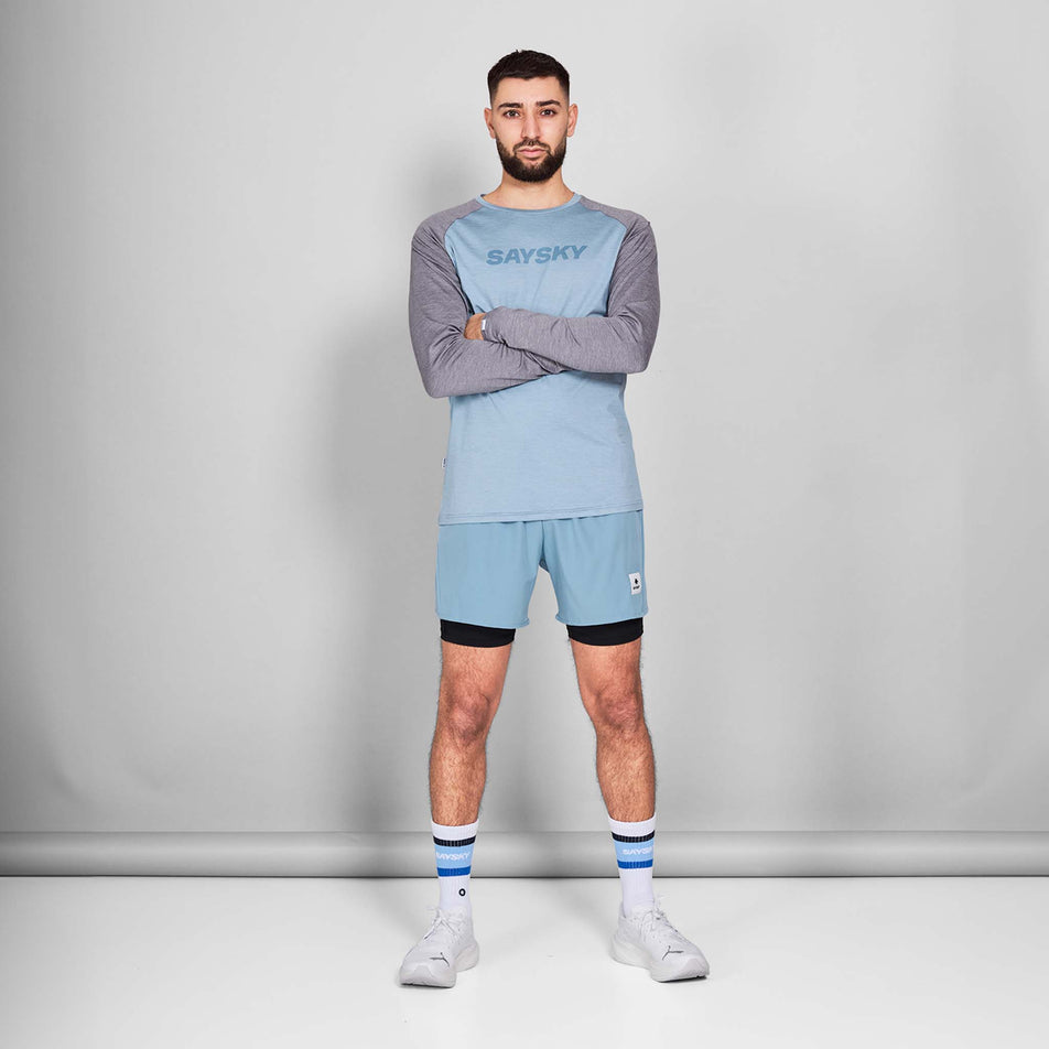 Front view of a model wearing the SAYSKY Men's Logo Pace Long Sleeve in the Blue Melange colourway. Model is also wearing shoes, socks and shorts. (8601261670562)
