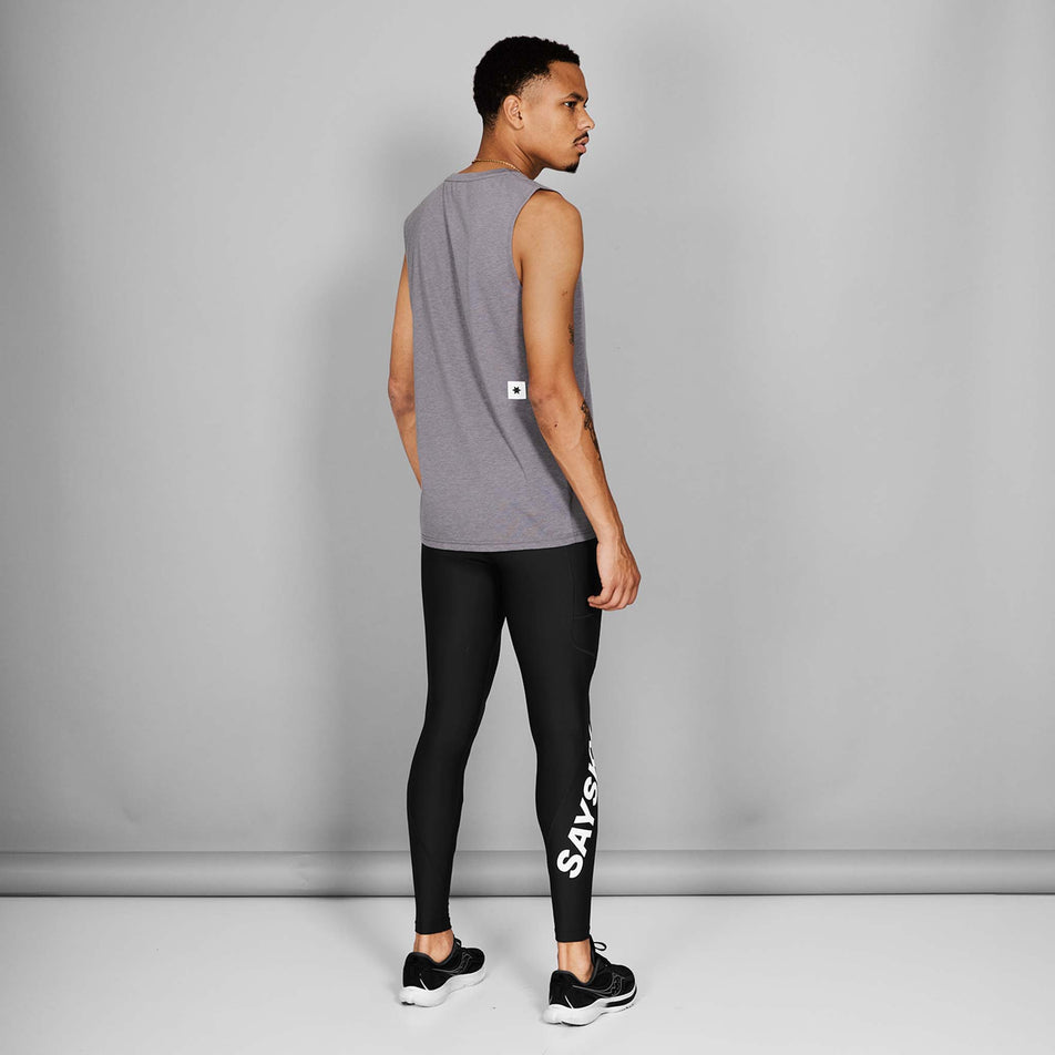 Back view of a model wearing a pair of the SAYSKY Men's Logo Motion+ Long Tights in the Black colourway. Model is also wearing shoes and a top. (8601278808226)