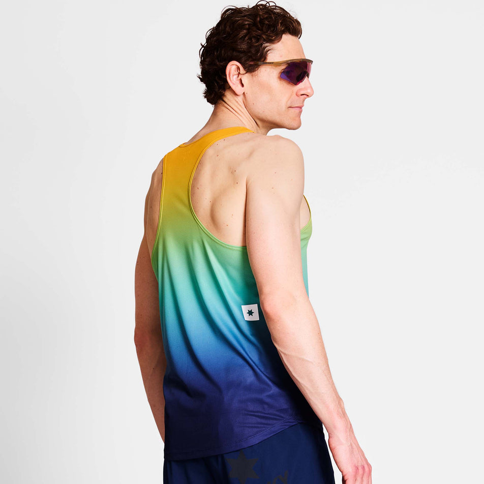 Back view of a model wearing a SAYSKY Men's Drip Dye Flow Singlet in the Blue AOP colourway. Model is also wearing sunglasses and legwear. (8675465986210)