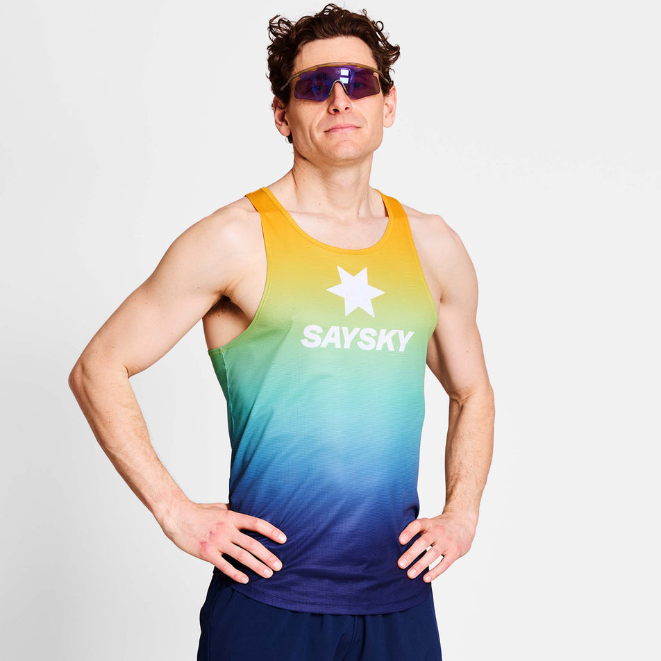 Front view of a model wearing a SAYSKY Men's Drip Dye Flow Singlet in the Blue AOP colourway. Model is also wearing sunglasses and legwear. (8675465986210)