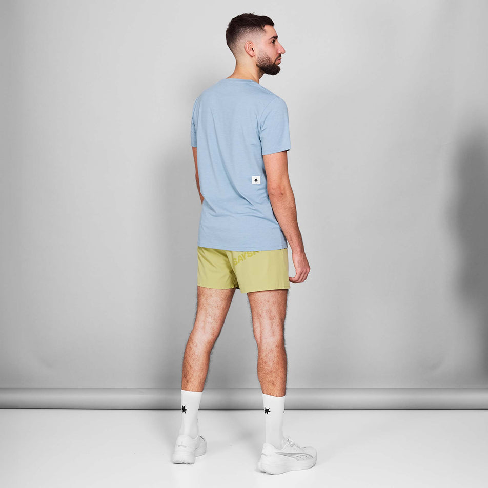Back view of a model wearing the SAYSKY Men's Logo Pace T-Shirt in the Blue Melange colourway. Model is also wearing shoes, socks and shorts. (8601301647522)