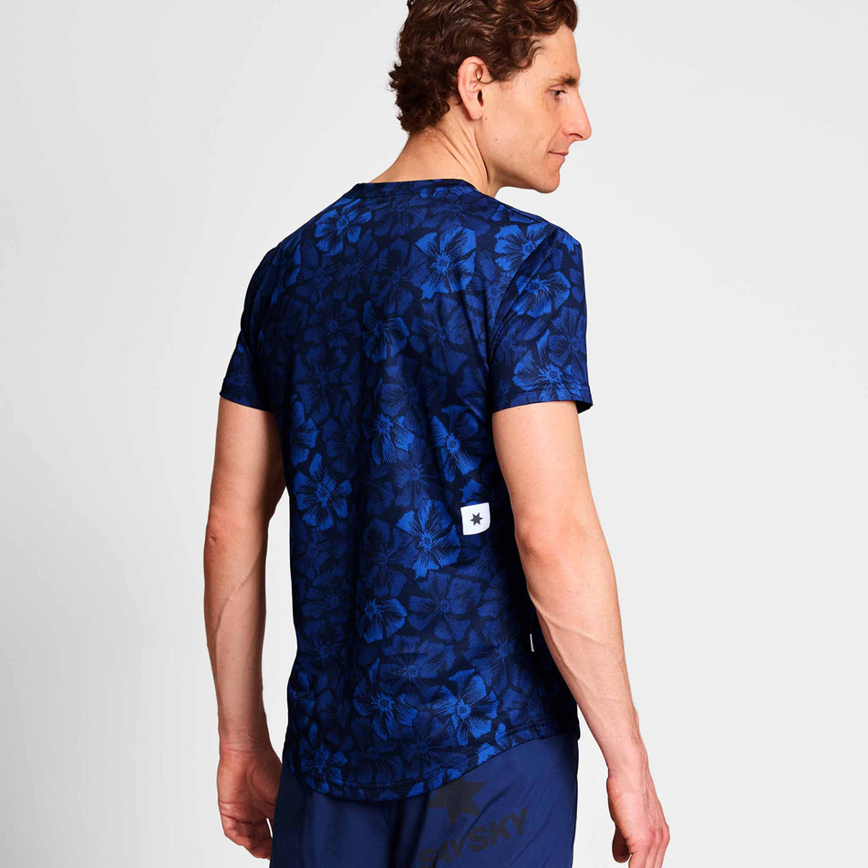 Back view of a model wearing a SAYSKY Men's Flower Combat T-Shirt in the Blue AOP colourway. Model is also wearing legwear. (8663034364066)
