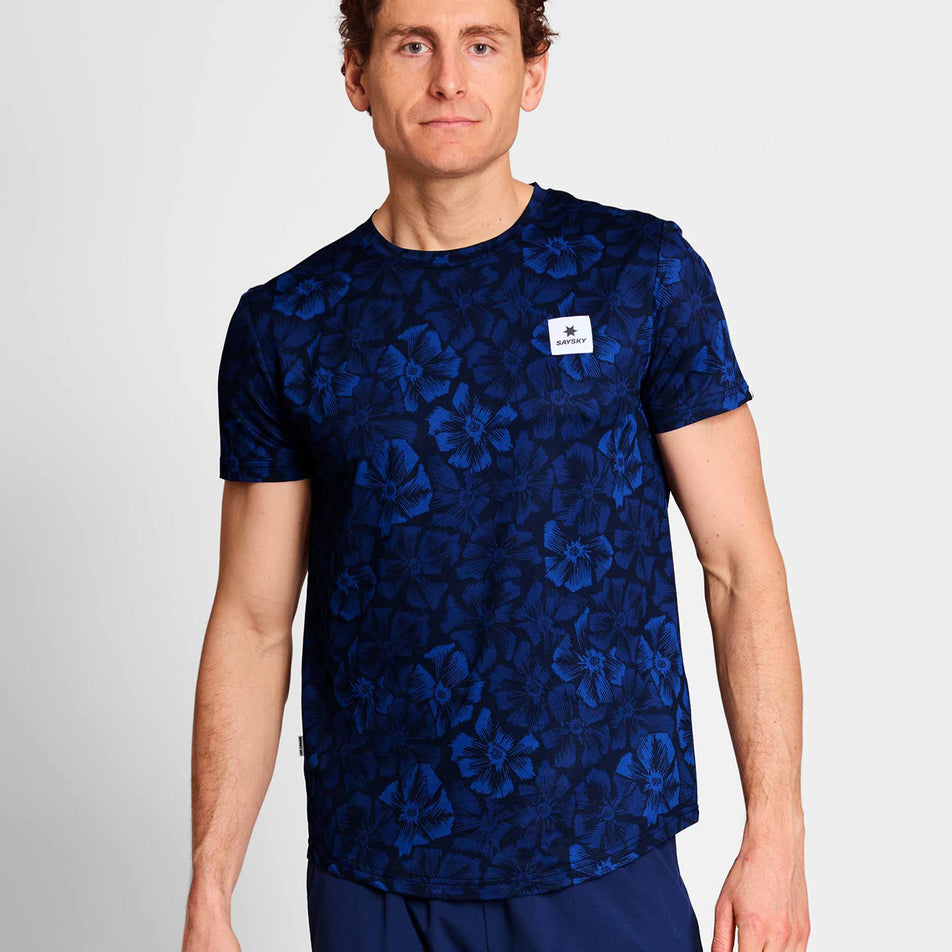 Front view of a model wearing a SAYSKY Men's Flower Combat T-Shirt in the Blue AOP colourway. Model is also wearing legwear. (8663034364066)