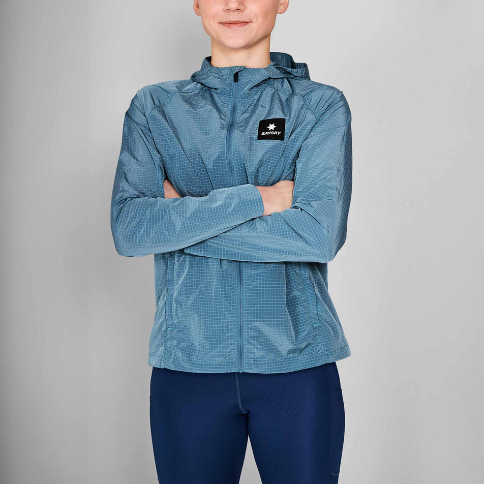Back view of a model wearing the SAYSKY Women's Clean Pace Shield Jacket in the Blue colourway. Model is also wearing tights. (8601993445538)