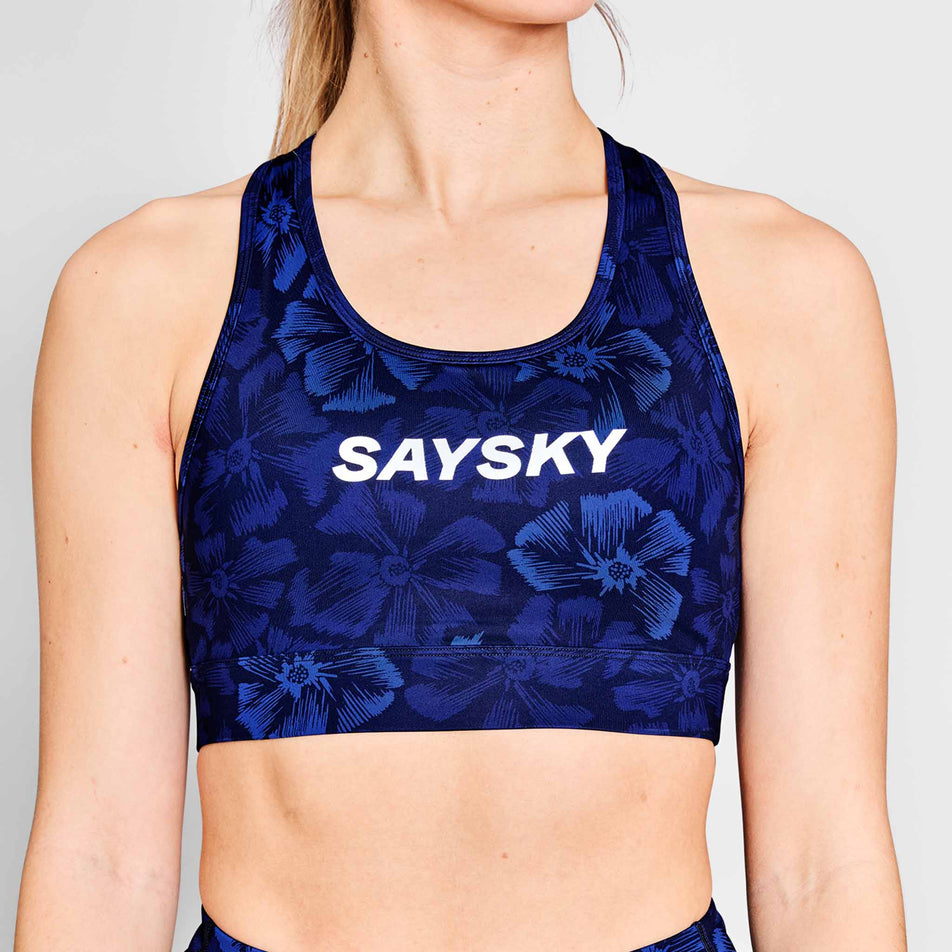Front view of a model wearing a SAYSKY Women's Flower Combat Sports Bra in the Blue AOP colourway. (8663041015970)