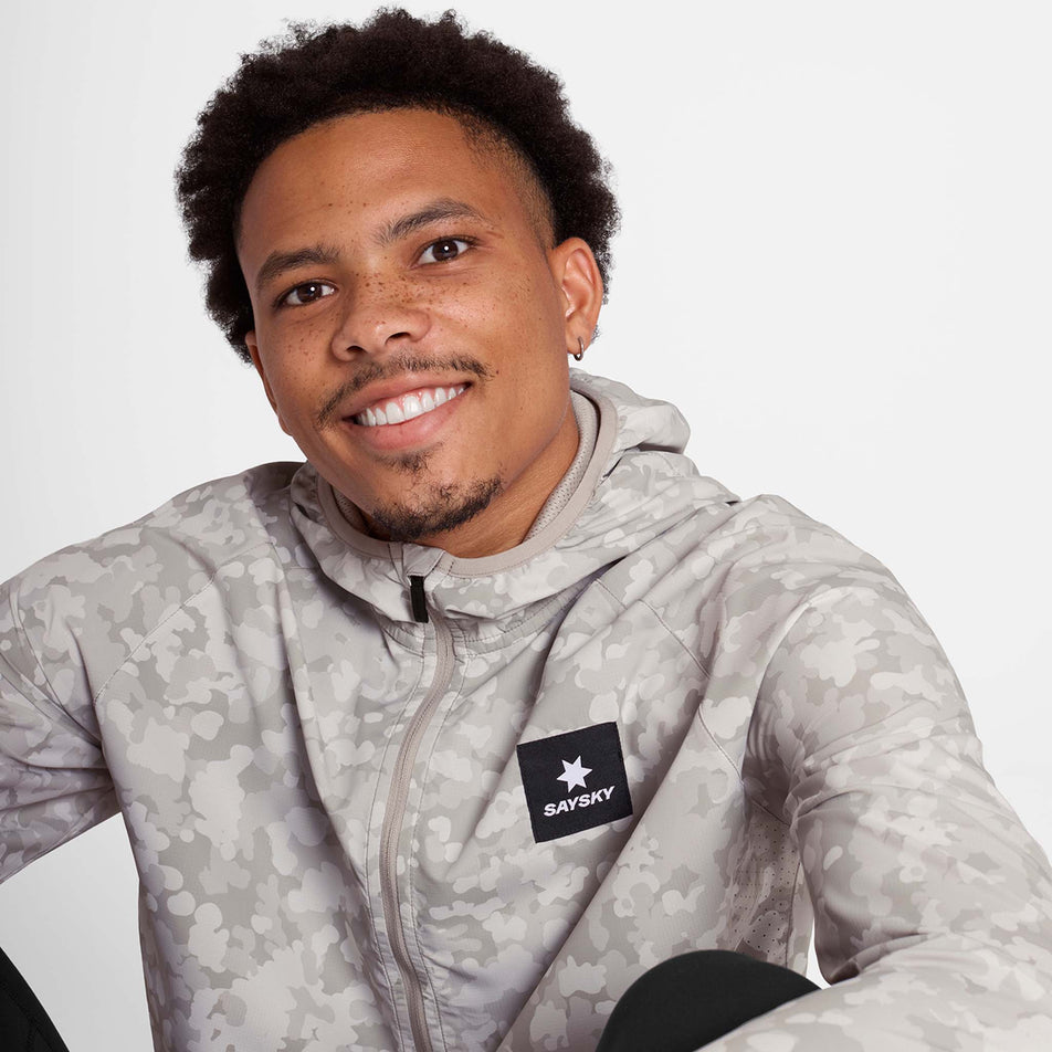 Front view of a model wearing the SAYSKY Men's Camo Pace Jacket in the White colourway. (8781019578530)