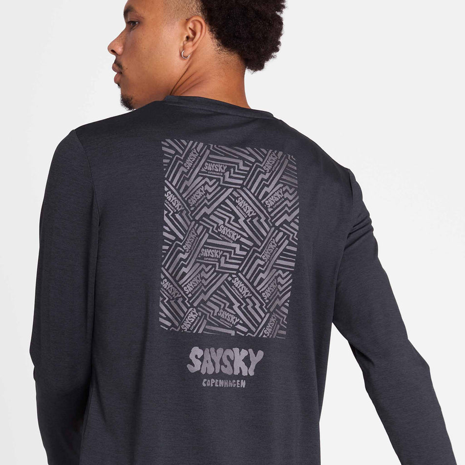 Back view of a model wearing the SAYSKY Men's Reflective Logo Pace Long Sleeve in the Black colourway.(8788224344226)