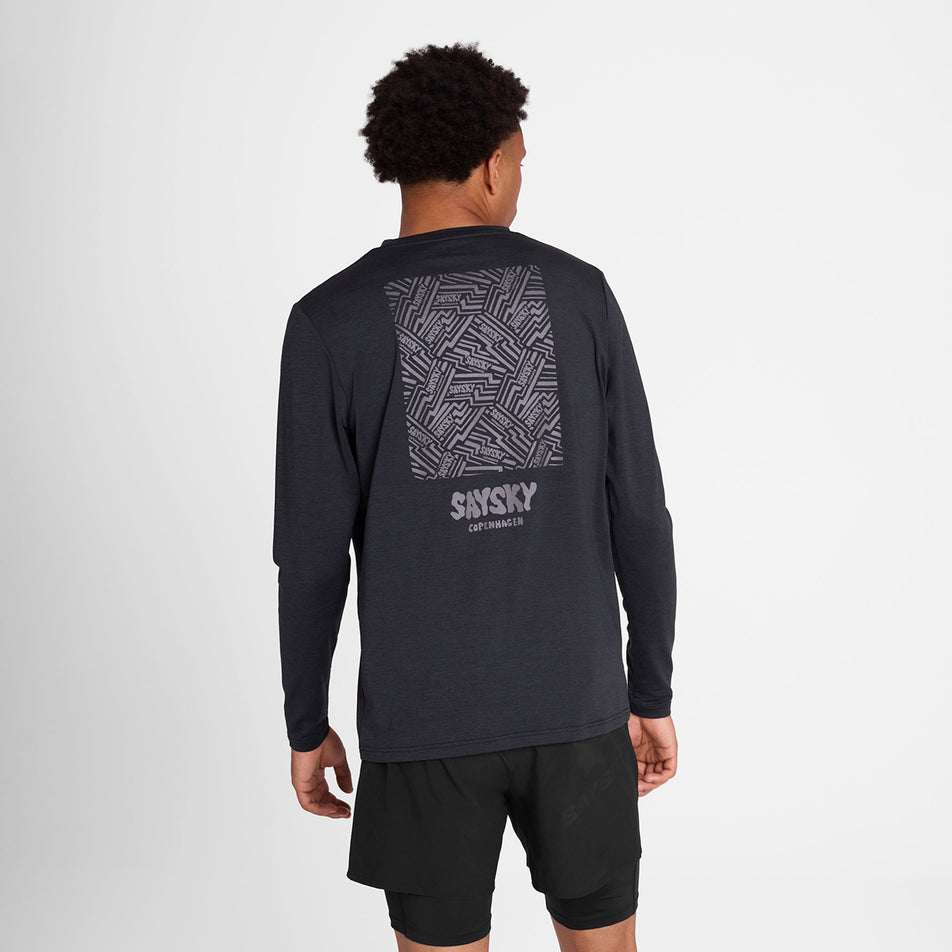 Back view of a model wearing the SAYSKY Men's Reflective Logo Pace Long Sleeve in the Black colourway. (8788224344226)