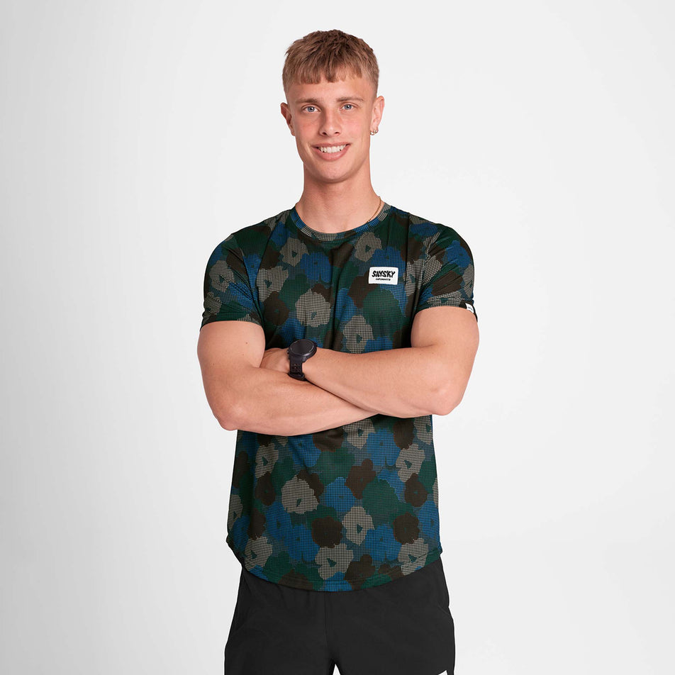 Front view of a model wearing the SAYSKY Men's Flower Combat T-Shirt in the Blue AOP colourway. Model is also wearing shorts. (8756181434530)