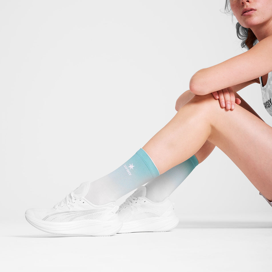 Side view of a model wearing the SAYSKY Unisex Combat Socks in the Blue AOP colourway. (8731011678370)