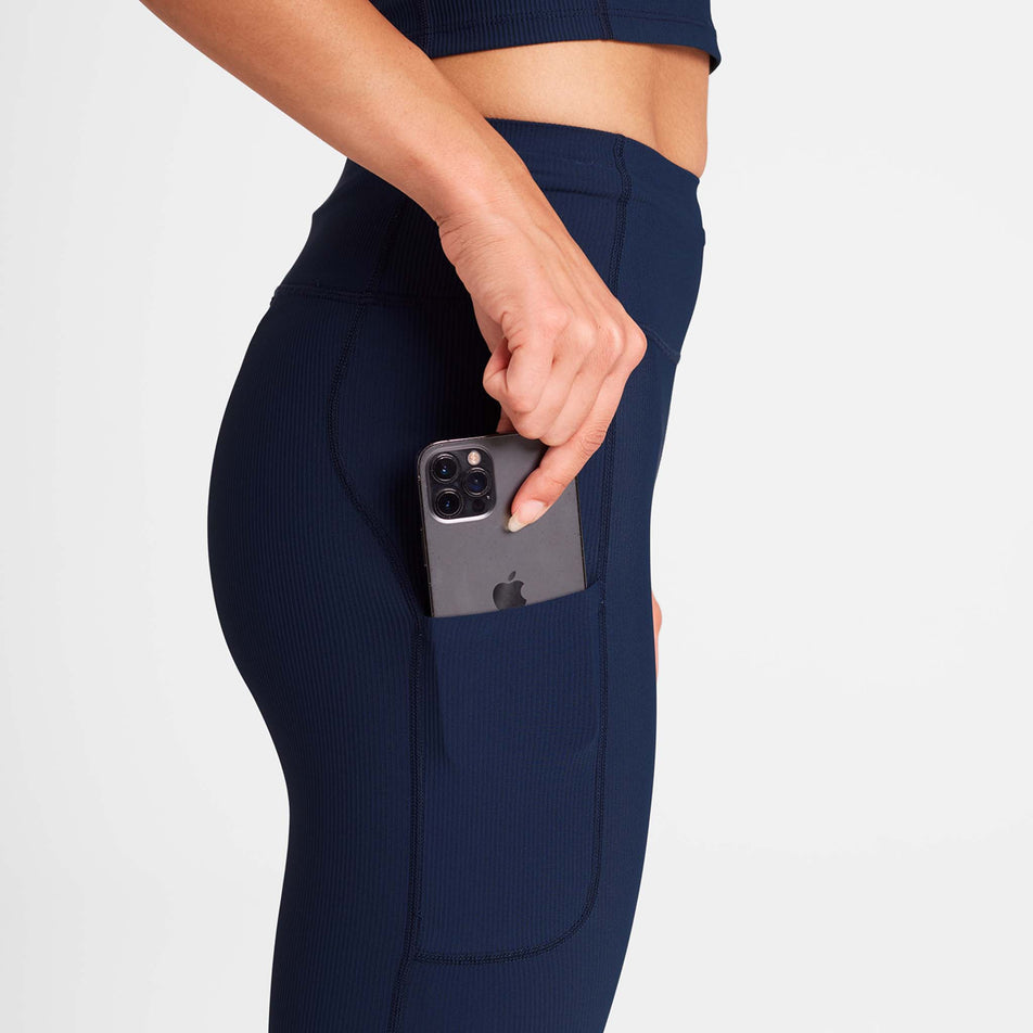 A model demonstrating the drop-in pocket on the side of the SAYSKY Women's Combat+ Rib Long Tights in the Blue colourway. (8730937196706)