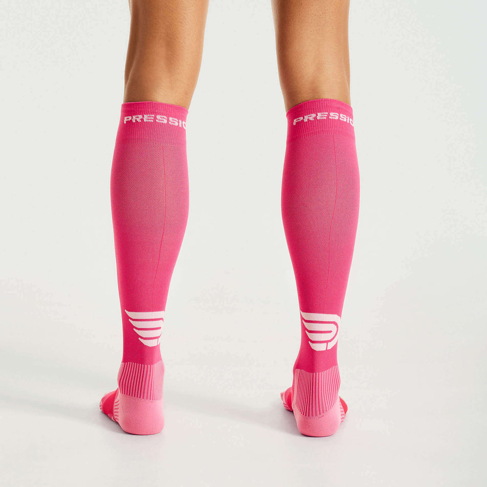 Back view of a model wearing the Pressio Unisex EQ Compression Socks in the Pink/Red colourway. (8341600632994)