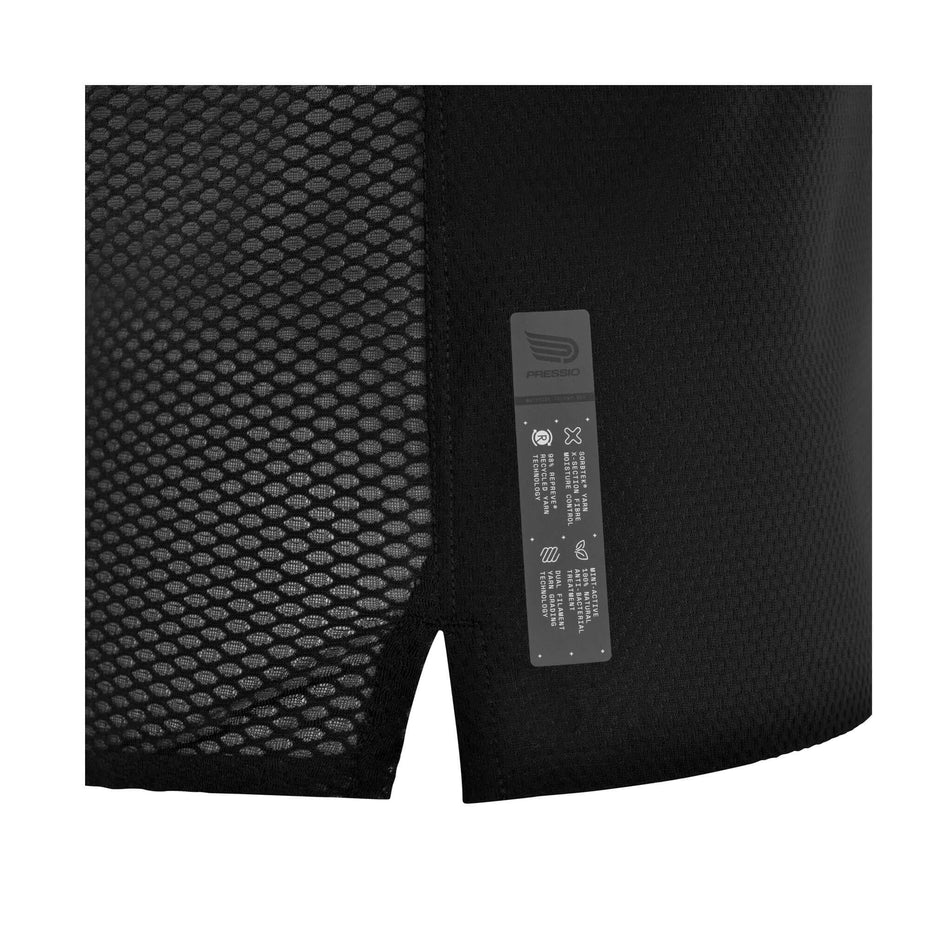 Close-up view of the label with logo and technical details, just above the the lower-right hem of the Pressio Women's Elite S/S Top in the Black colourway. (8475844149410)