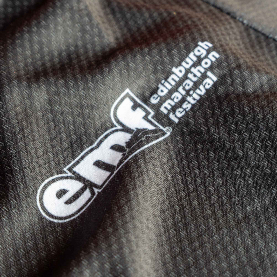 Close-up of the EMF logo on the front of a Pressio Men's Elite S/S Top from the range of EMF Official Licensed Merchandise (8668923199650)