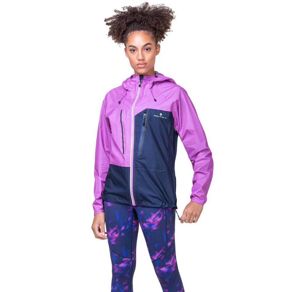 Front view of a model wearing the Women's Tech Fortify Jacket in the Dark Navy/Fuchsia colourway. Model is also wearing Ronhill leggings. (8160855752866)