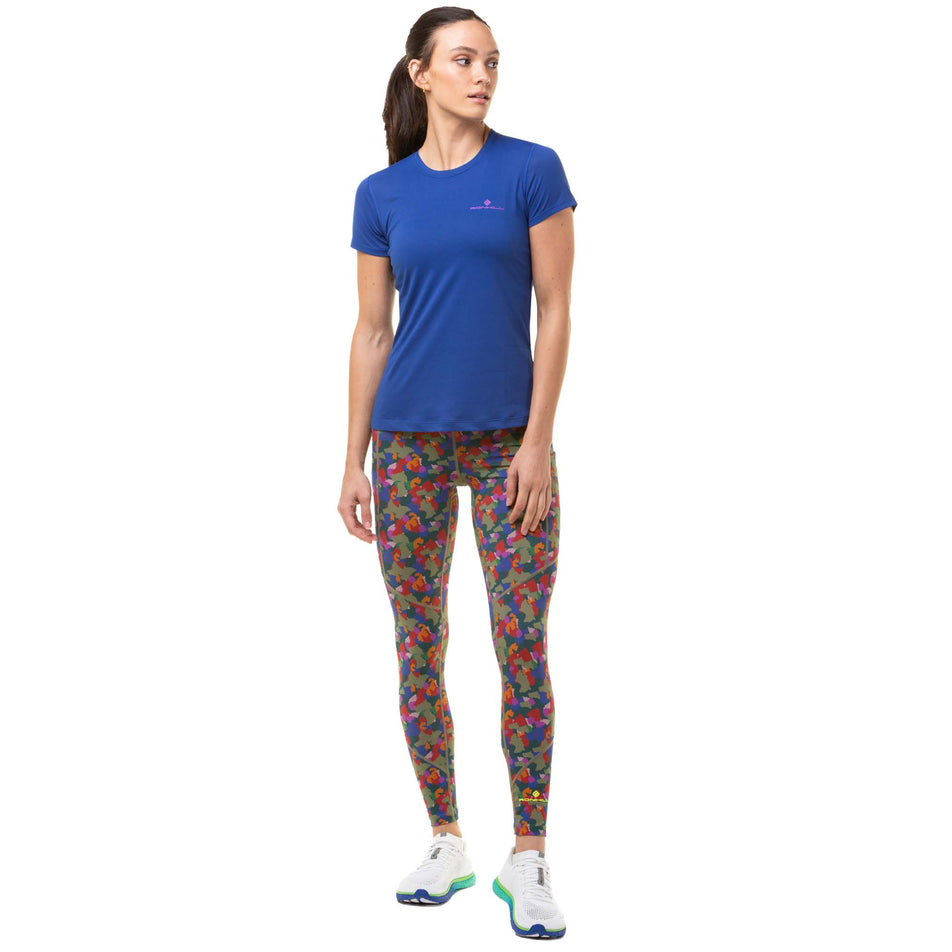 Front view of a model wearing a Ronhill Women's Core S/S Tee in the Dark Cobalt/Thistle colourway. Model is also wearing Ronhill running leggings and Altra running shoes. (8047488729250)