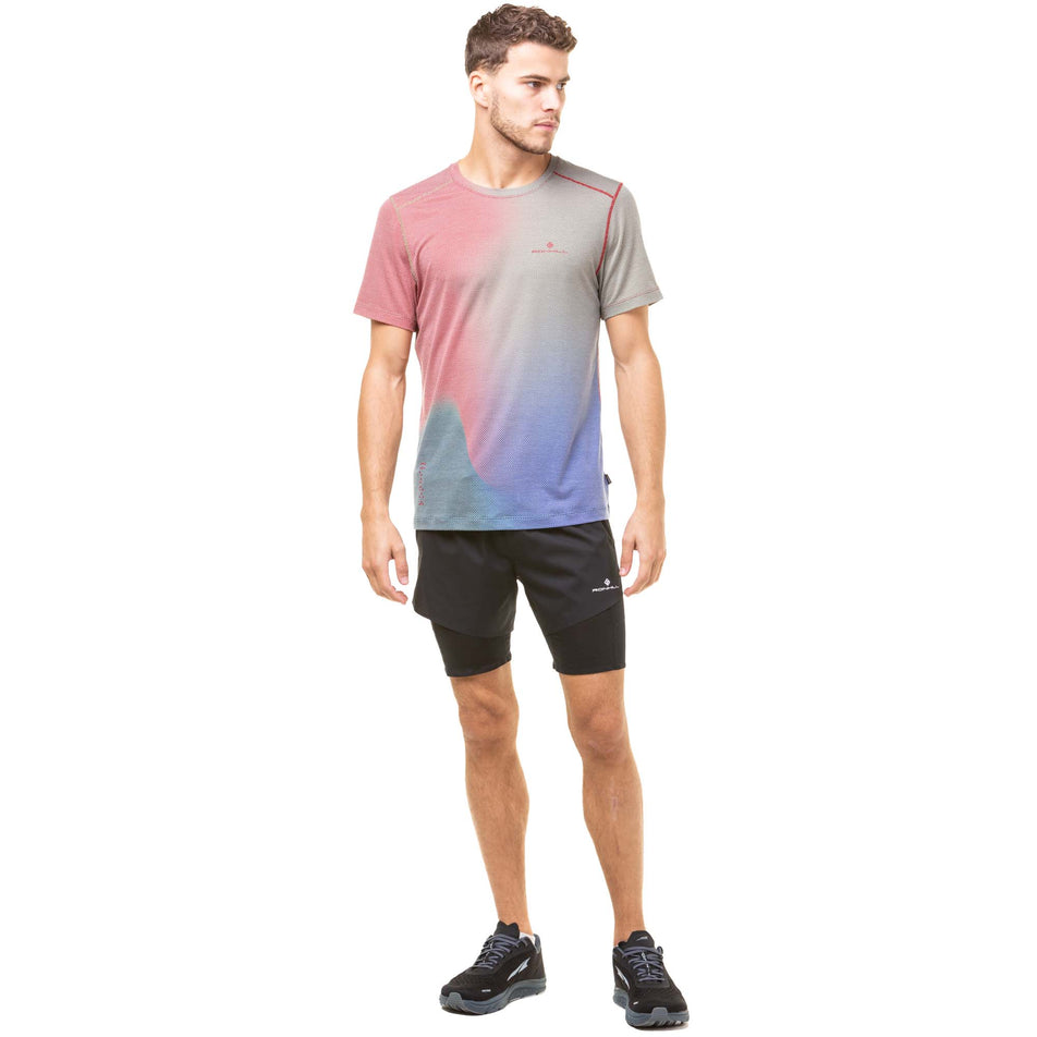 Front view of a model wearing a Ronhill Men's Tech Golden Hour Tee in the Jam/Deep Lagoon Merge colourway. Model also wearing black Ronhill running shorts and Altra running shoes.  (8032265142434)