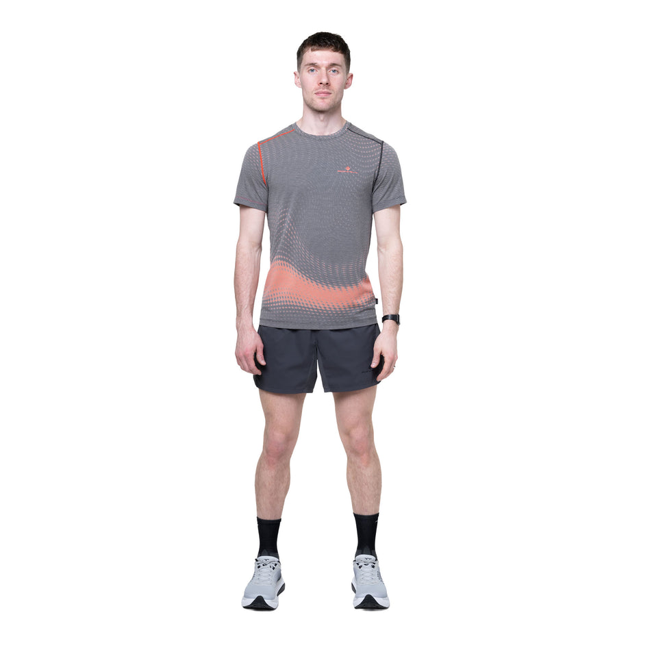 Front view of a model wearing the Ronhill Men's Tech Golden Hour S/S Tee in the Ronhill Red Motion colourway.