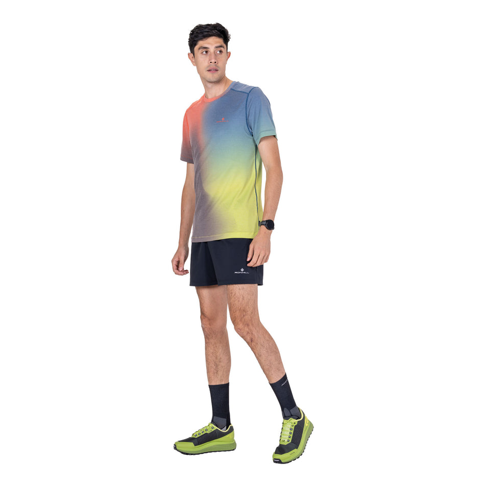 Front view of a model wearing the Ronhill Men's Tech Golden Hour S/S Tee in the Ronhill Red Merge colourway.