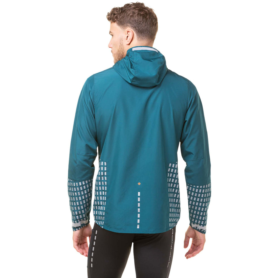 Back view of a model wearing a Ronhill Men's Tech Afterhours Jacket in the Deep Lagoon/Copper Reflect colourway. Model is also wearing Ronhill running tights. (8047865364642)