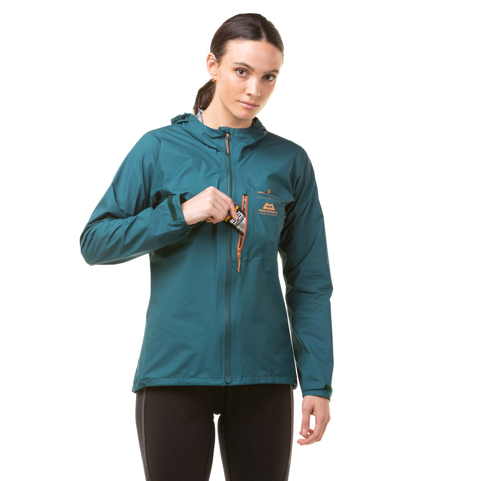 A model demonstrating that an energy gel can be stored in the zipped chest pocket on a Ronhill Women's Gore-Tex Mercurial Jacket (8059839119522)