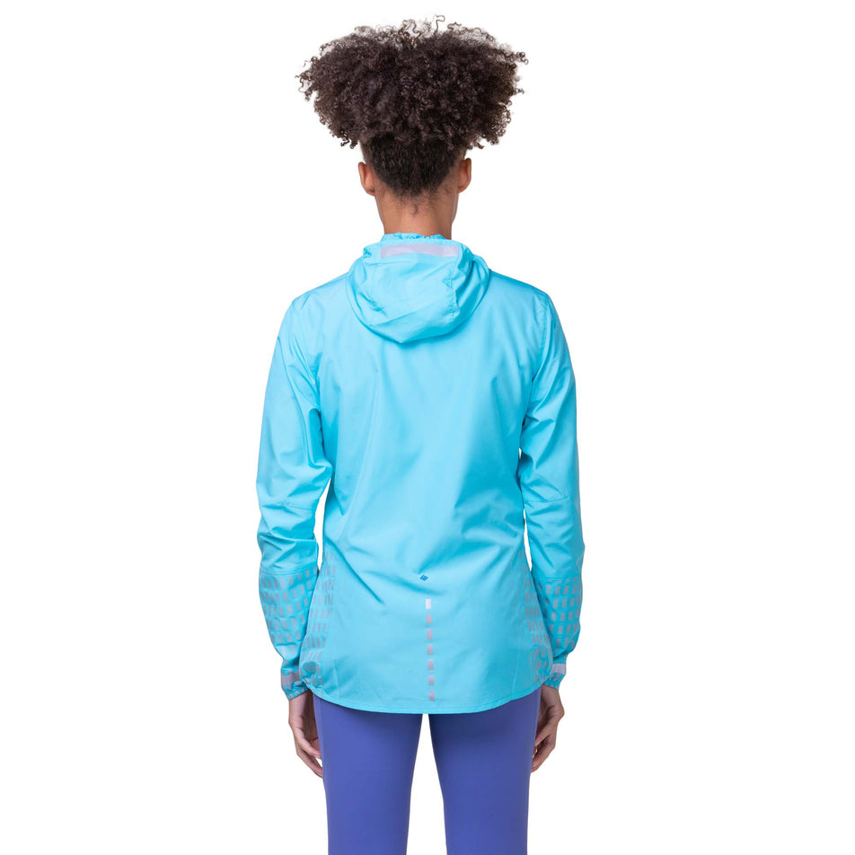 Back view of a model wearing the Ronhill Women's Tech Afterhours Jacket in the Aquamint/Reflect colourway. Model is also wearing Ronhill leggings. (8160853983394)
