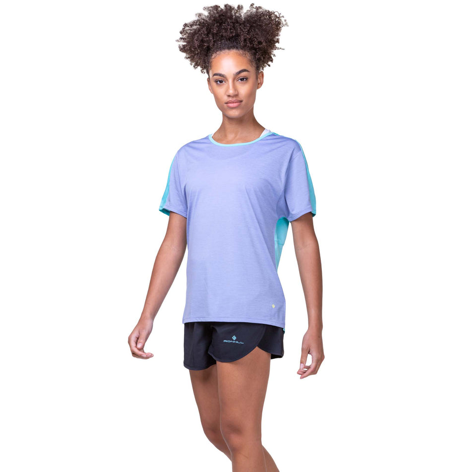 Front view of a model wearing a Ronhill Women's Tech Glide S/S Tee in the Periwinkle Marl/Aquamint colourway. Model is also wearing Ronhill shorts.  (8159375294626)