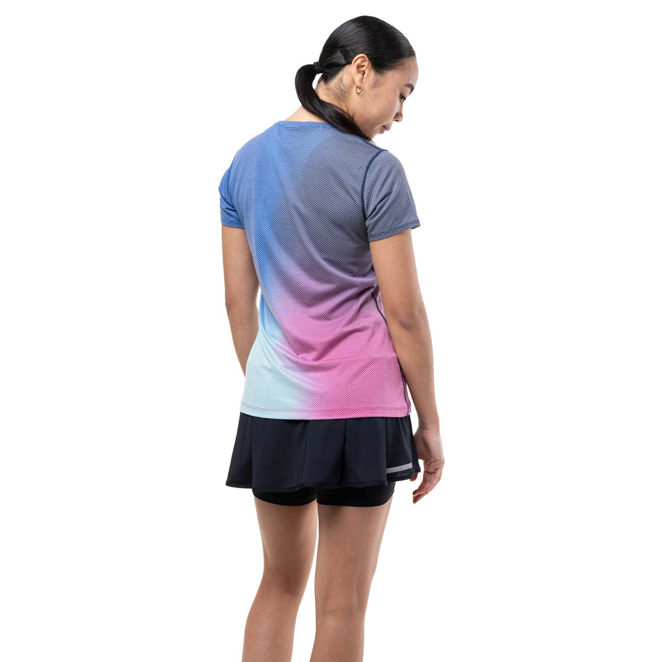 Back view of a model wearing the Ronhill Women's Tech Golden Hour S/S Tee in the Exuberance Merge colourway.