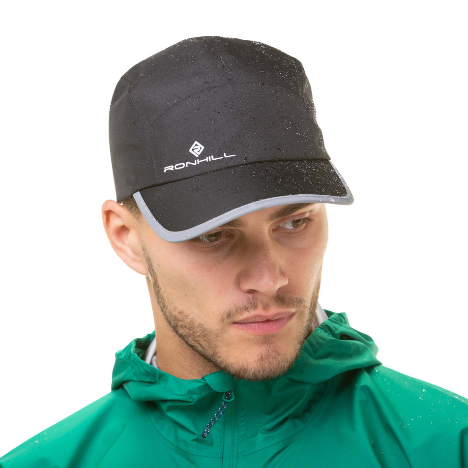 Front view of a model wearing a Ronhill Unisex Fortify Cap in the All Black colourway (8033746714786)