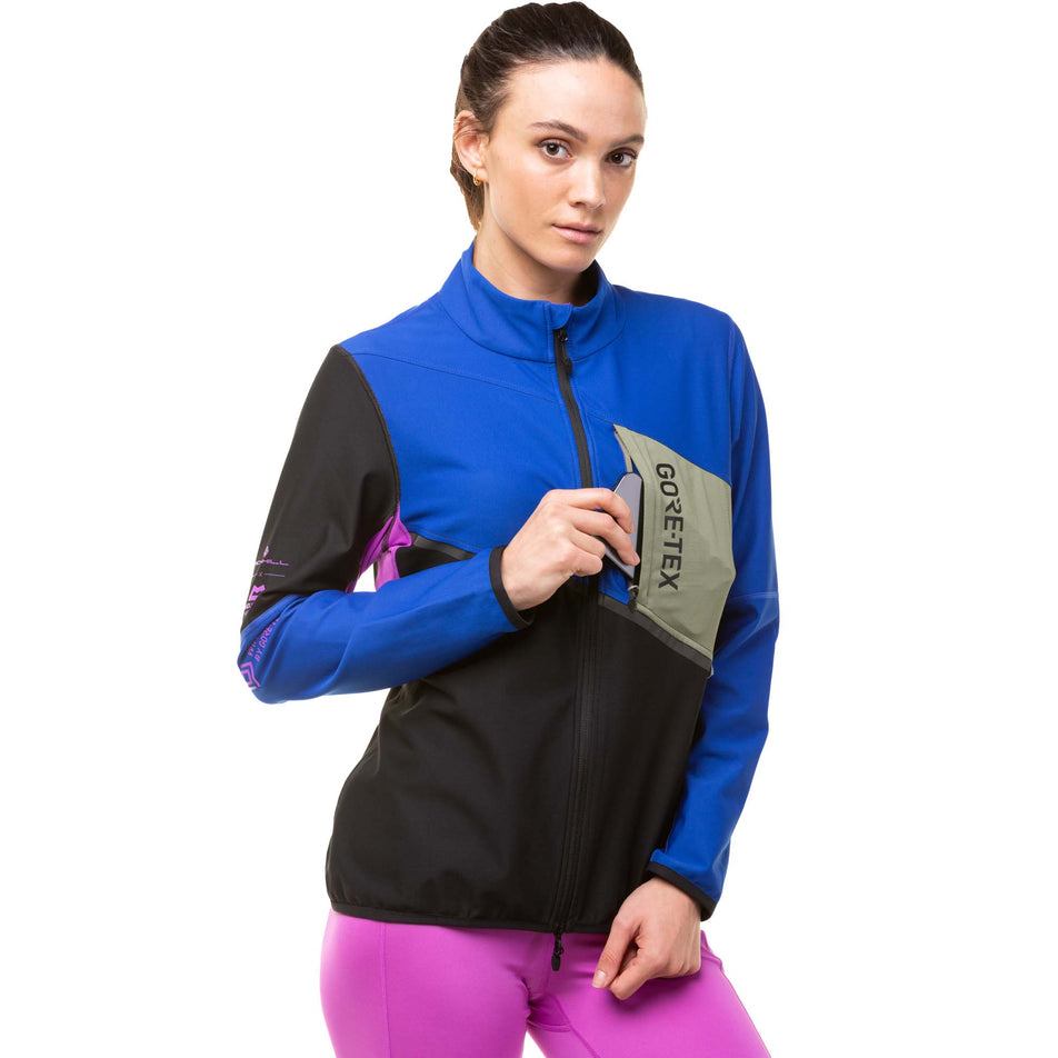A model demonstrating that a phone can be stored in the zipped chest pocket on a Ronhill Tech Gore-Tex Windstopper Jacket (8024339841186)