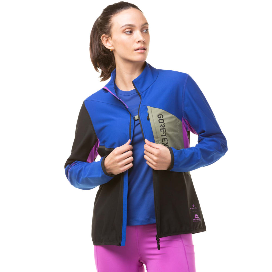 A model demonstrating that the two front sides of a Ronhill Tech Gore-Tex Windstopper Jacket can be fastened together at the chest - when the jacket is unzipped. (8024339841186)