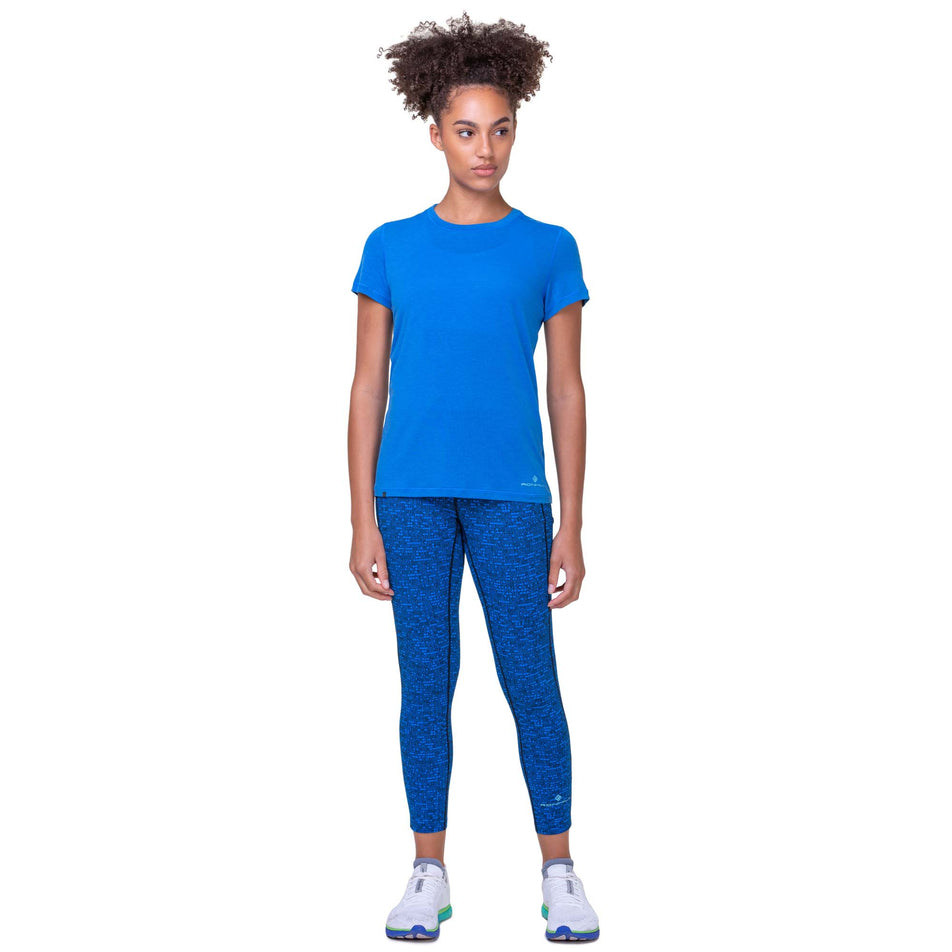 Front view of a model wearing the Women's Tech Tencel S/S Tee in the Electric Blue Marl colourway. Model is also wearing Ronhill leggings and Altra running shoes.  (8160831963298)