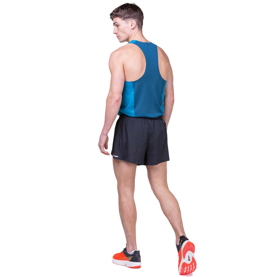 Back view of a model wearing the Ronhill Men's Tech Race Short in All Black colourway. Model is also wearing a Ronhill top and Altra running shoes. (8160873119906)