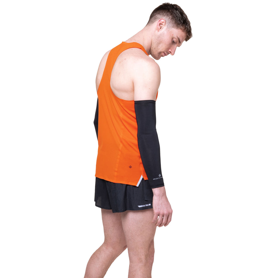Angled view of a model wearing the Ronhill Men's Tech Race Vest in the Ronhill Red/Black colourway.