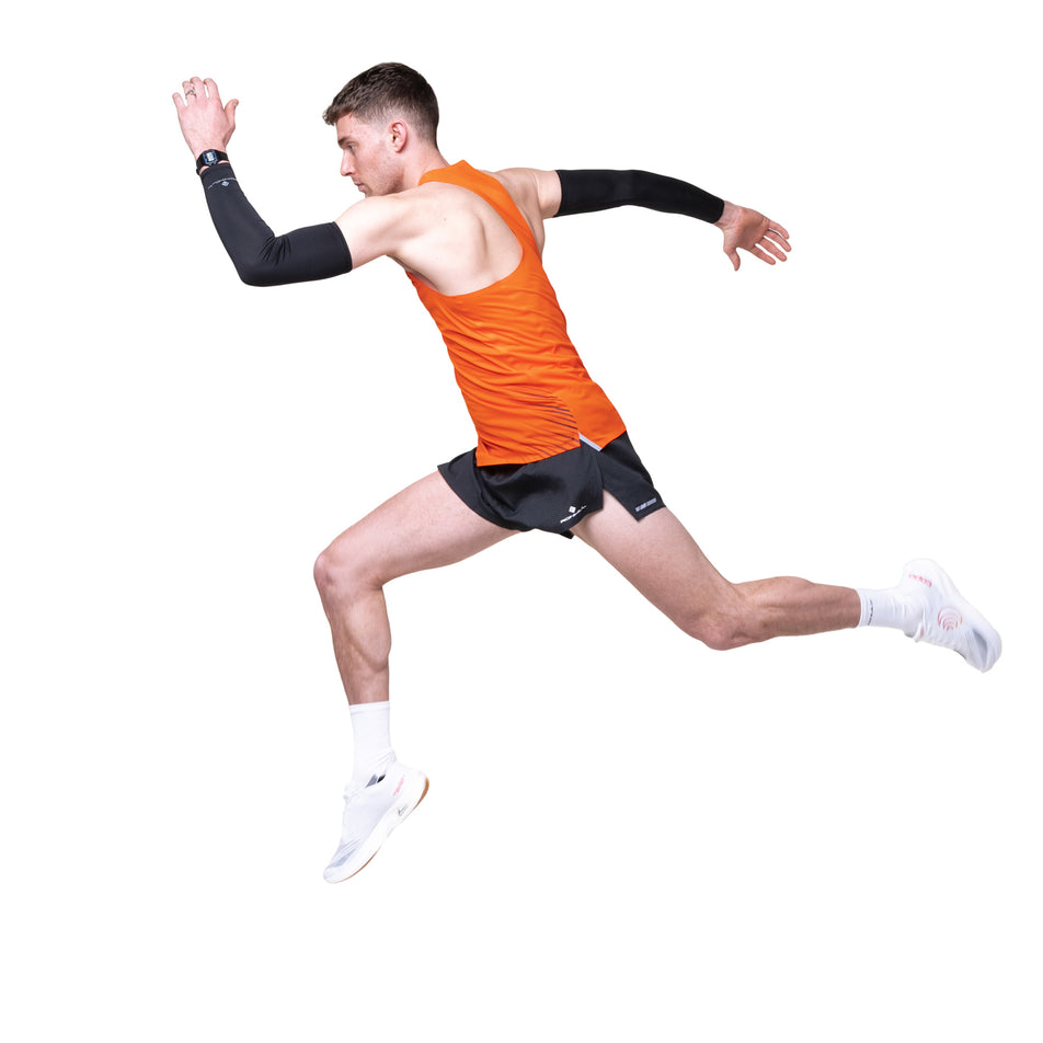 Side view of a model wearing the Ronhill Men's Tech Race Vest in the Ronhill Red/Black colourway.