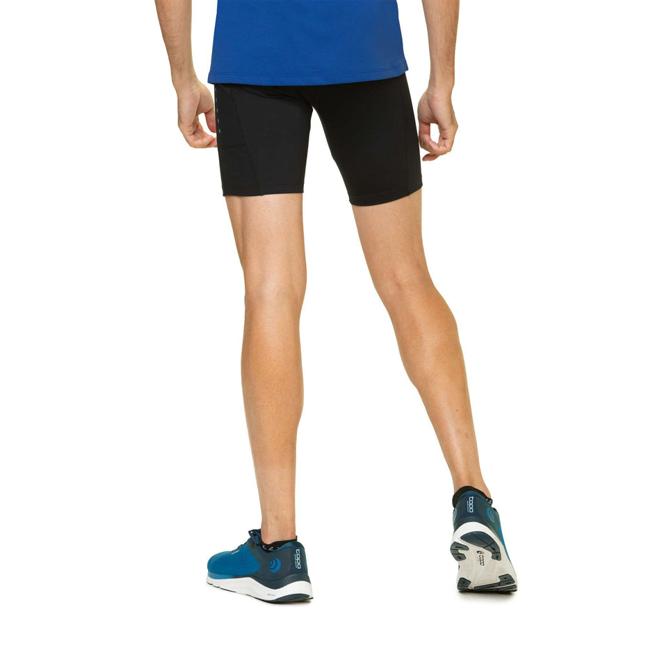 Back view of a model wearing the Ronhill Men's Core Stretch Short in the All Black colourway. Model is also wearing blue Rohill top and Topo Athletic shoes. (8160894976162)