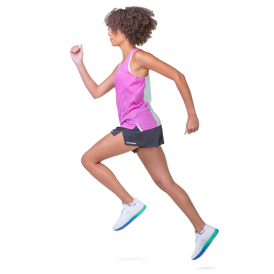 Side view of a model wearing the Ronhill Women's Tech Race Short in the All Black colourway. Model is also wearing a Ronhill top and Altra running shoes. Model is in a running pose. (8157947527330)