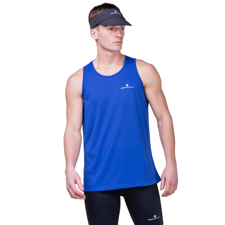 Front view of a model wearing a Ronhill Unisex Sunlight Vizor in the All Black colourway. Model is also wearing a Ronhill top and shorts. (8160952451234)
