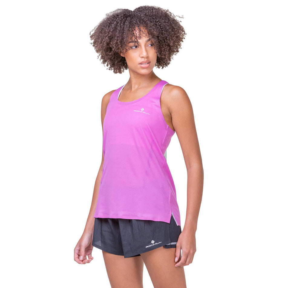Front view of a model wearing a Women's Tech Race Vest in the Fuchsia/Honeydew colourway. Model is also wearing Ronhill shorts. (8159305826466)