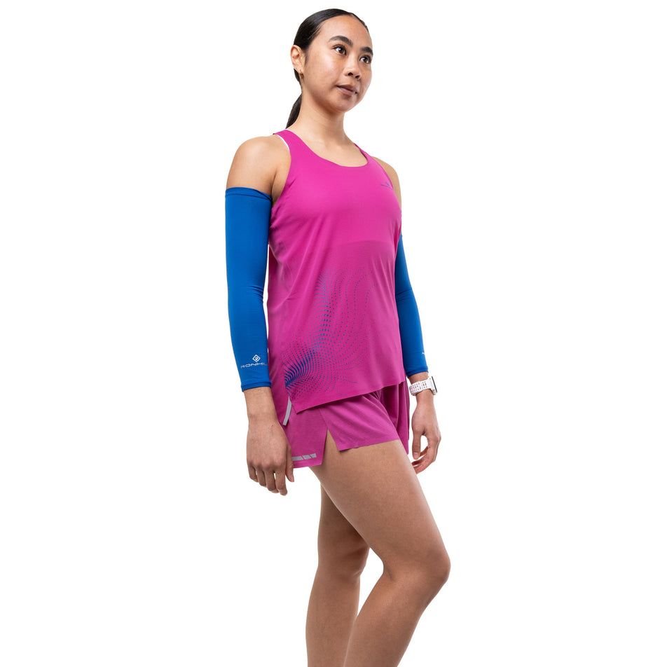 Angled view of a model wearing the Ronhill Women's Tech Race Vest in the Exuberance/Classic Blue colourway.
