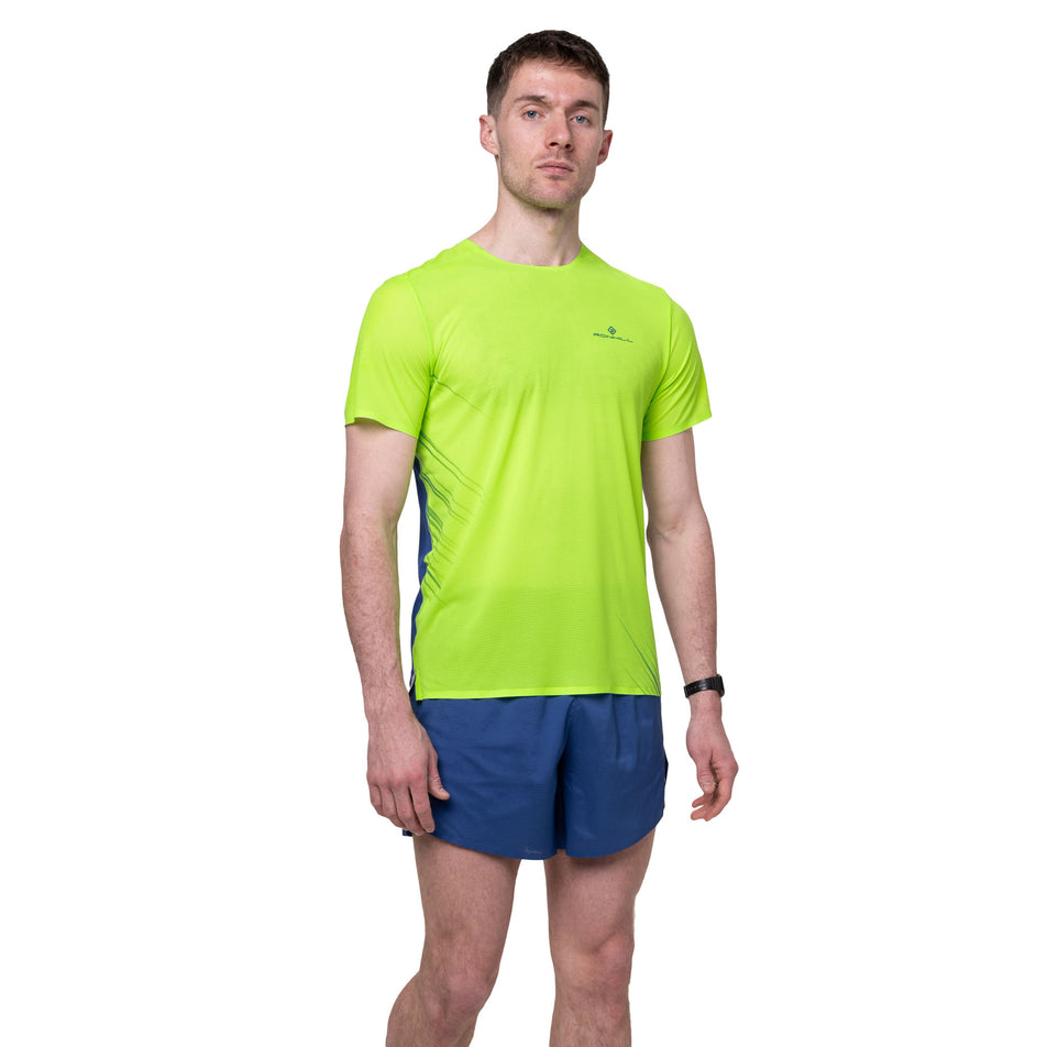 Front view of a model wearing the Ronhill Men's Tech Race S/S Tee in the Fluo Green/Dark Cobalt colourway.