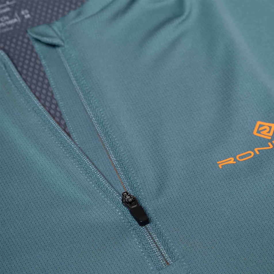 Close-up view of the zip on the front of the Ronhill Men's Tech 1/2 Zip S/S Tee in the Monolith/Artemis colourway. (8565244264610)