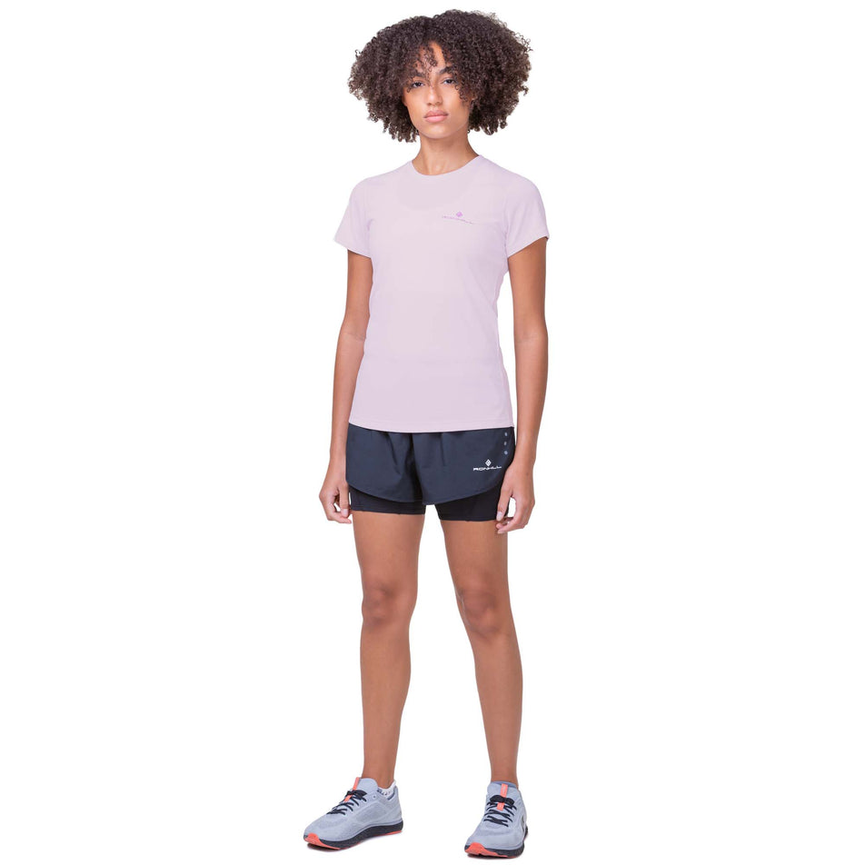 Front view of a model wearing a Ronhill Women's Core S/S Tee in the Ballet/Fuchsia colourway. Model is also wearing Ronhill shorts and Altra running shoes.. (8160858243234)